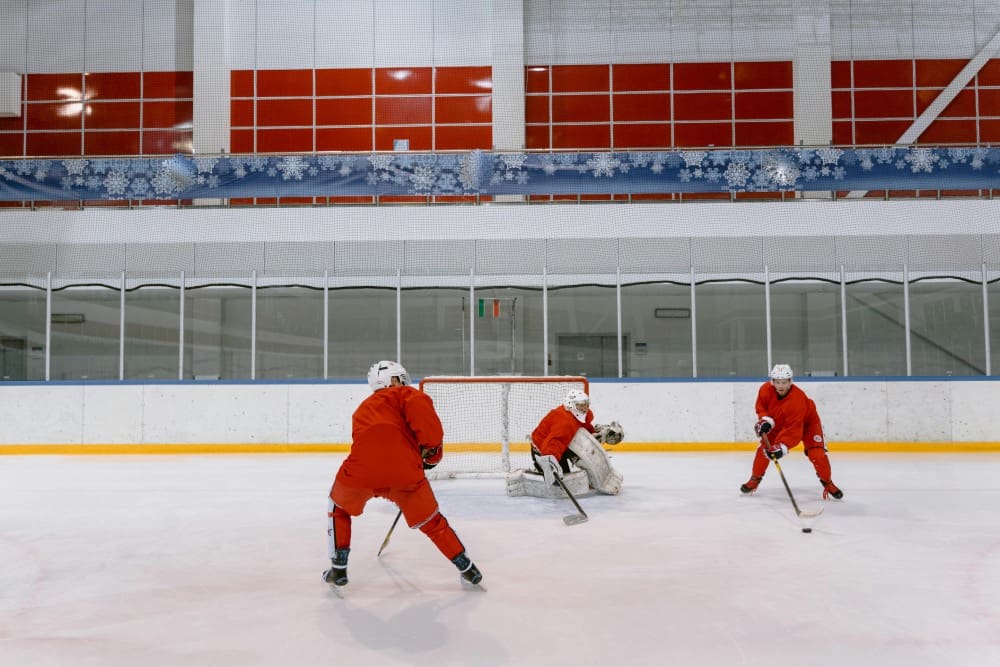 A group of men playing hockey on an ice rink.